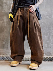 Person wearing brown wide-leg pants and yellow boots against a gray concrete wall.