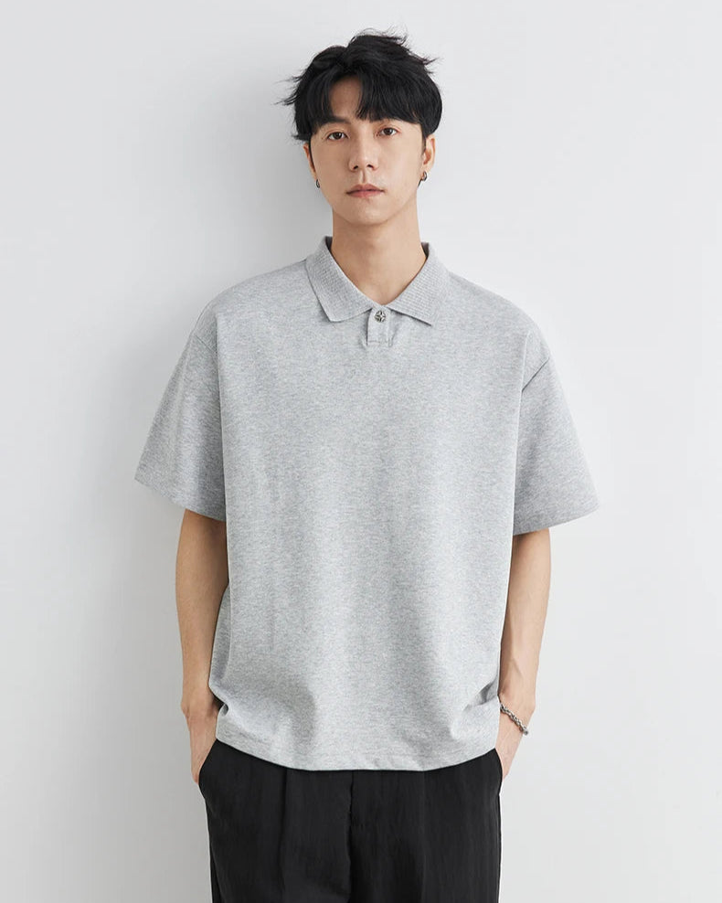 Man wearing a gray polo shirt against a white background