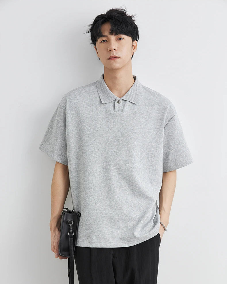 Man wearing a gray polo shirt against a white background