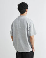 Person wearing a gray t-shirt on a light gray background