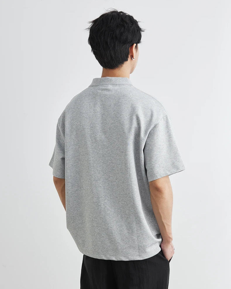 Person wearing a gray t-shirt on a light gray background