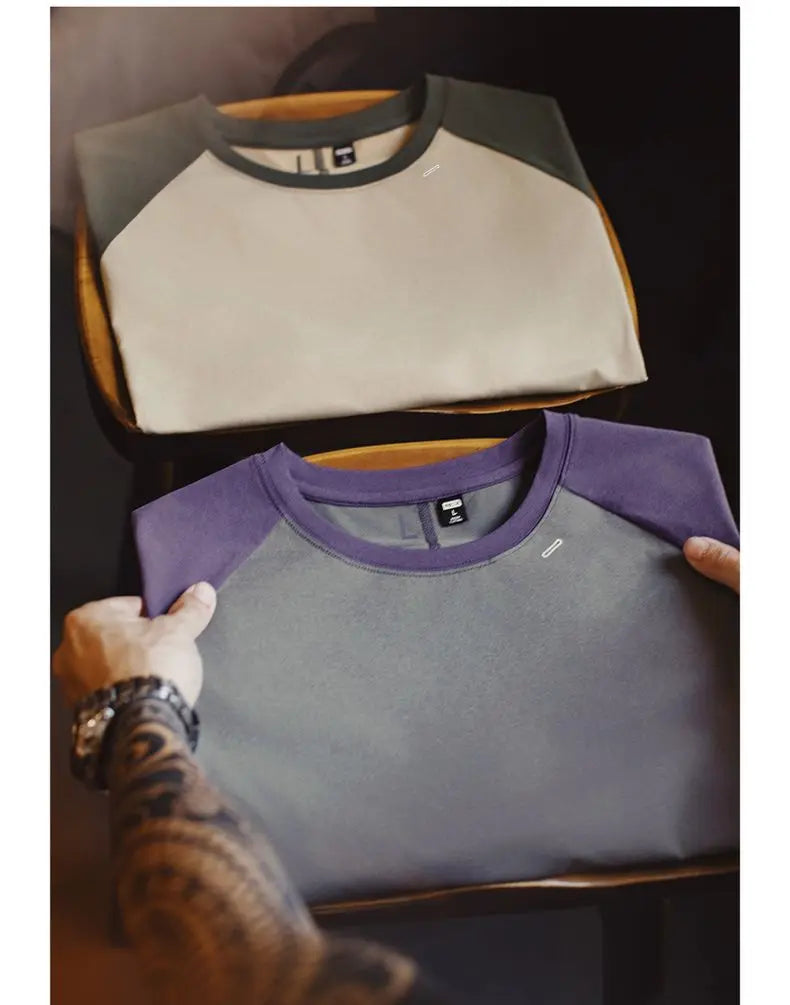 Gray and purple shirt with a brand logo on a dark background