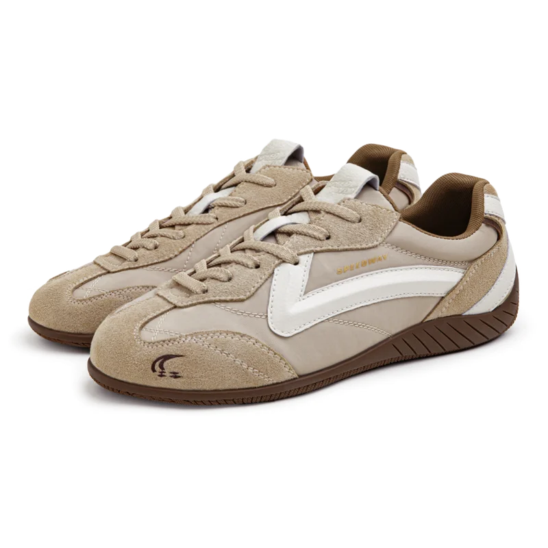 Pair of beige and brown sneakers with white accents on a white background