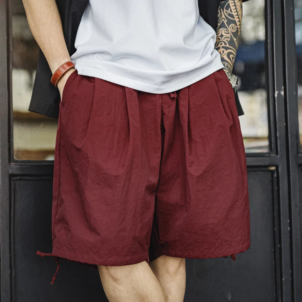 Person wearing maroon shorts and a white shirt with a blurred background