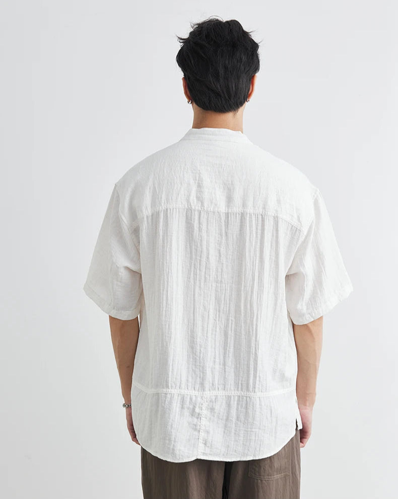 Person wearing a white textured shirt from behind on a light gray background