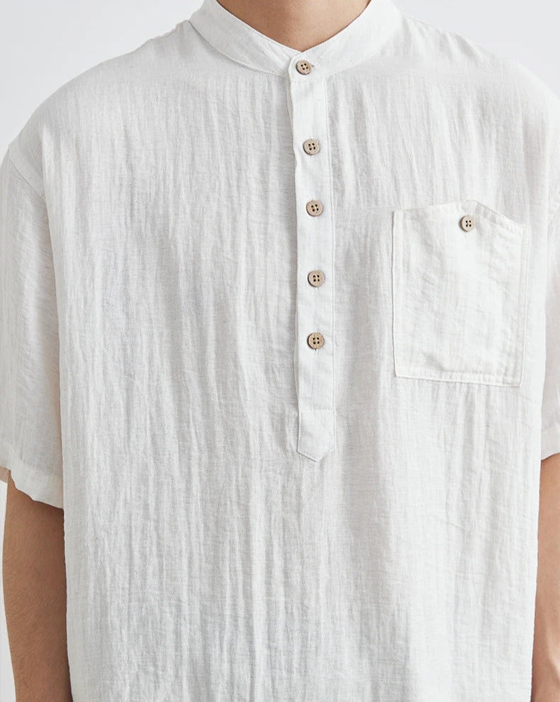 White textured shirt with buttons and a pocket on a plain background