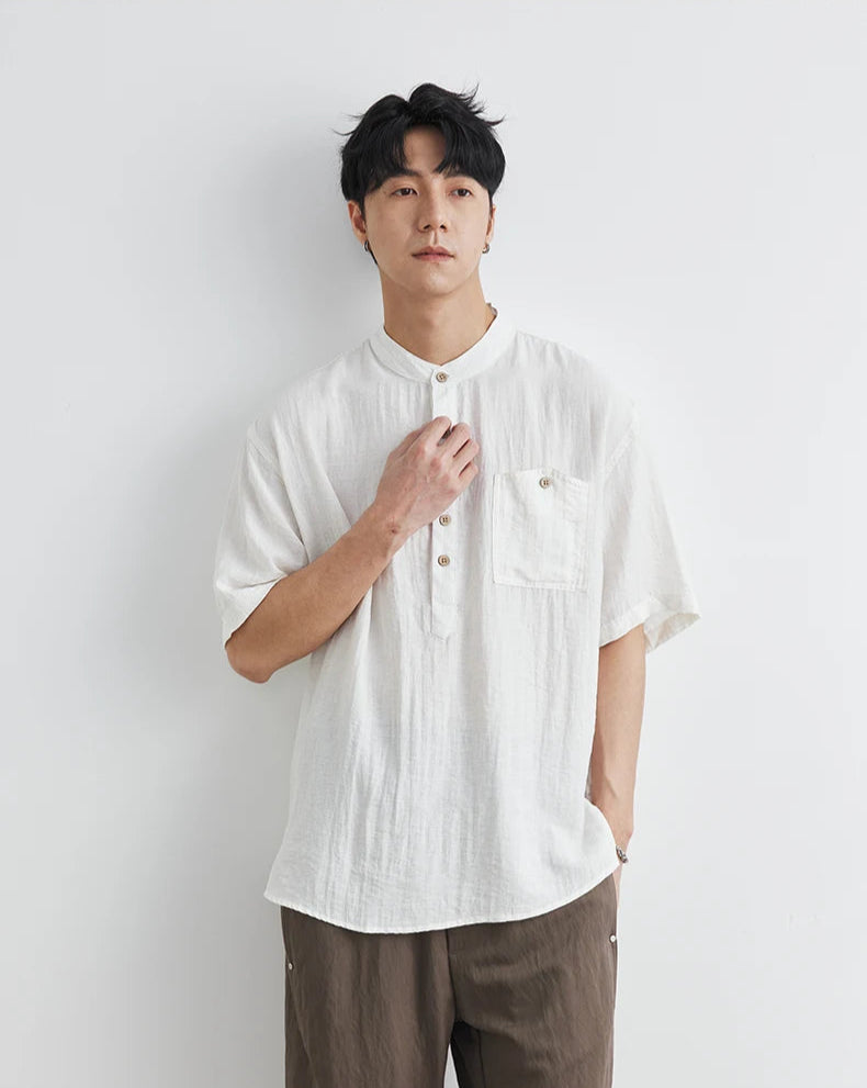 Man wearing a white shirt and brown pants against a white background