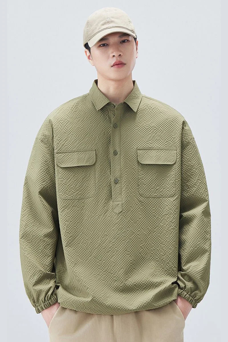 Person wearing a green textured shirt and beige cap on a white background