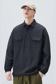 Person wearing a dark textured shirt and beige cap on a light gray background