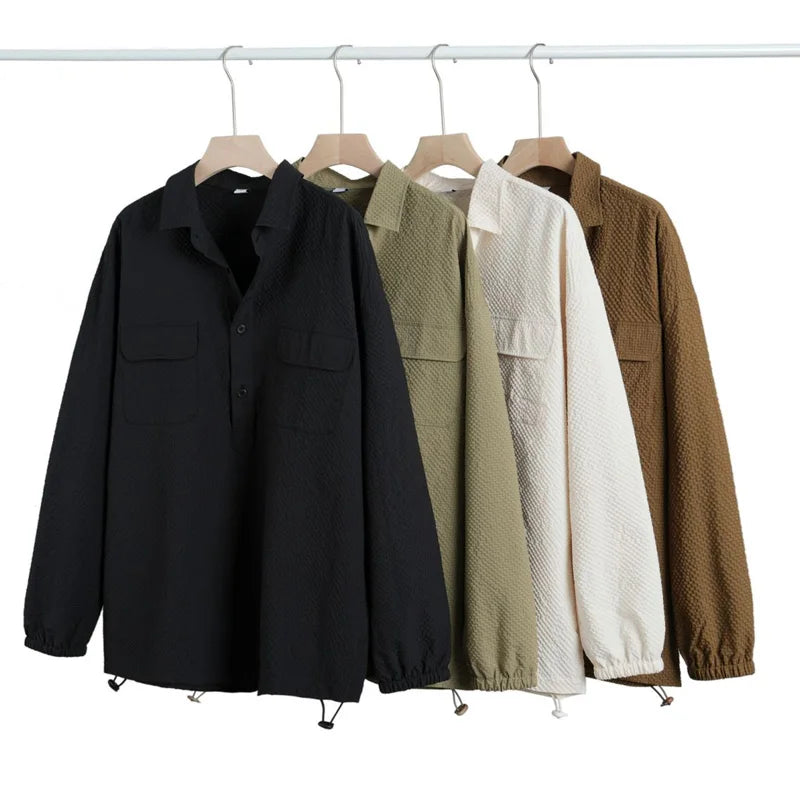 Four jackets in black, beige, white, and brown hanging on a rack against a white background.