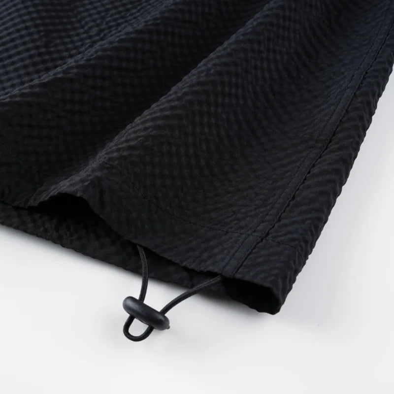 Black textured drawstring bag on a white background