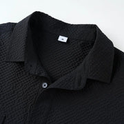 Black textured shirt with collar detail on a white background