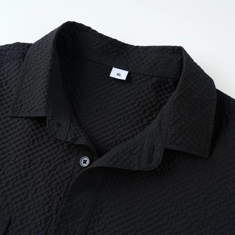 Black textured shirt with collar detail on a white background