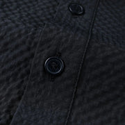 Close-up of a textured dark fabric with buttons