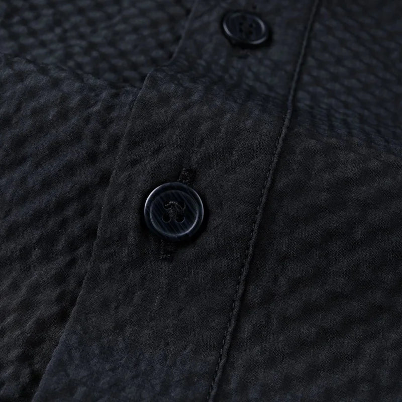 Close-up of a textured dark fabric with buttons