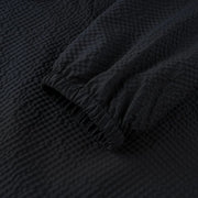 Close-up of textured black fabric with folds