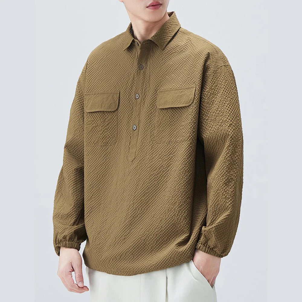 Person wearing a brown textured shirt on a light gray background