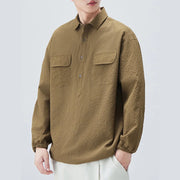 Person wearing a brown textured shirt on a light gray background