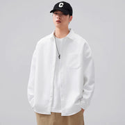 Person wearing a white shirt and black cap with a logo on a gray background