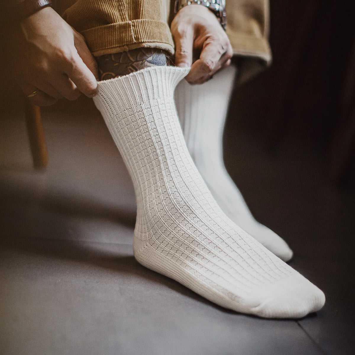 Person holding a white sock against a blurred background