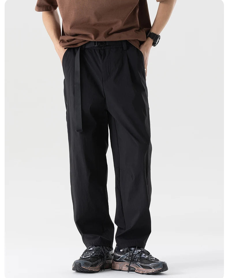Person wearing black pants and a brown shirt on a white background
