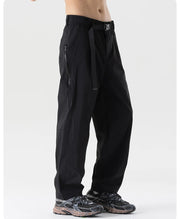 Black pants worn by a person on a white background