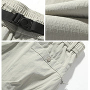 Collage of light gray pants with a black belt, close-up of fabric texture, and button detail.