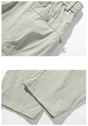 Light gray pants with a button detail on a white background