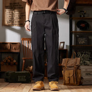 Person wearing black pants and brown shoes in a rustic indoor setting with a backpack and wooden furniture.