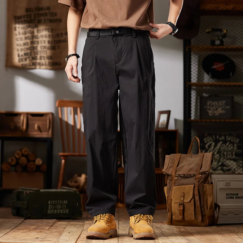 Person wearing black pants and brown shoes in a rustic indoor setting with a backpack and wooden furniture.