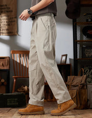 Person wearing beige workwear casual pants with brown boots in a room setting.