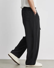 Person wearing black wide-leg pants with a plain background