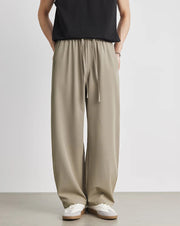 Person wearing beige wide-leg pants with a plain background