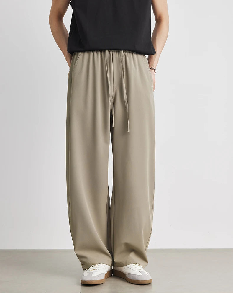 Person wearing beige wide-leg pants with a plain background