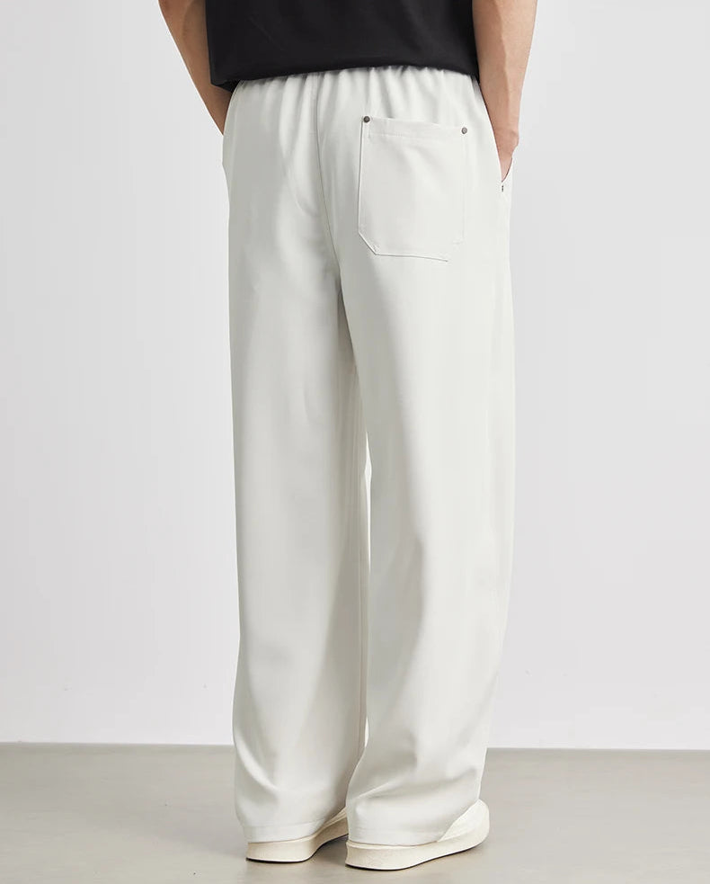 White pants worn by a person on a plain background