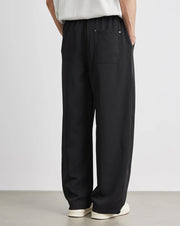 Person wearing black wide-leg pants with a white background