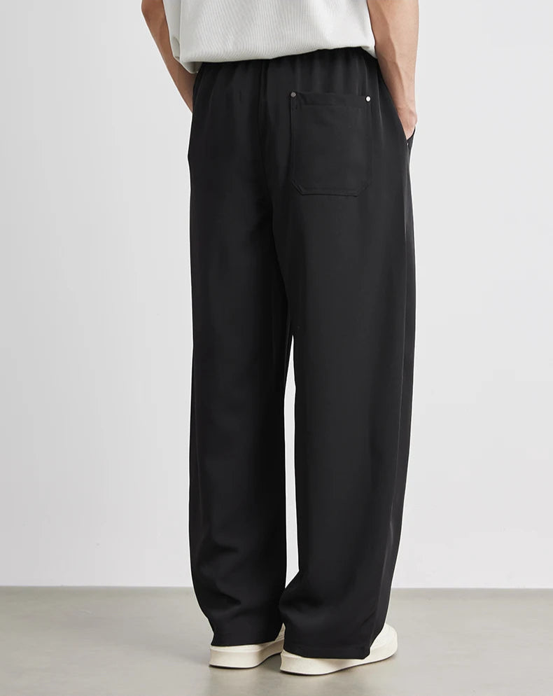 Person wearing black wide-leg pants with a white background