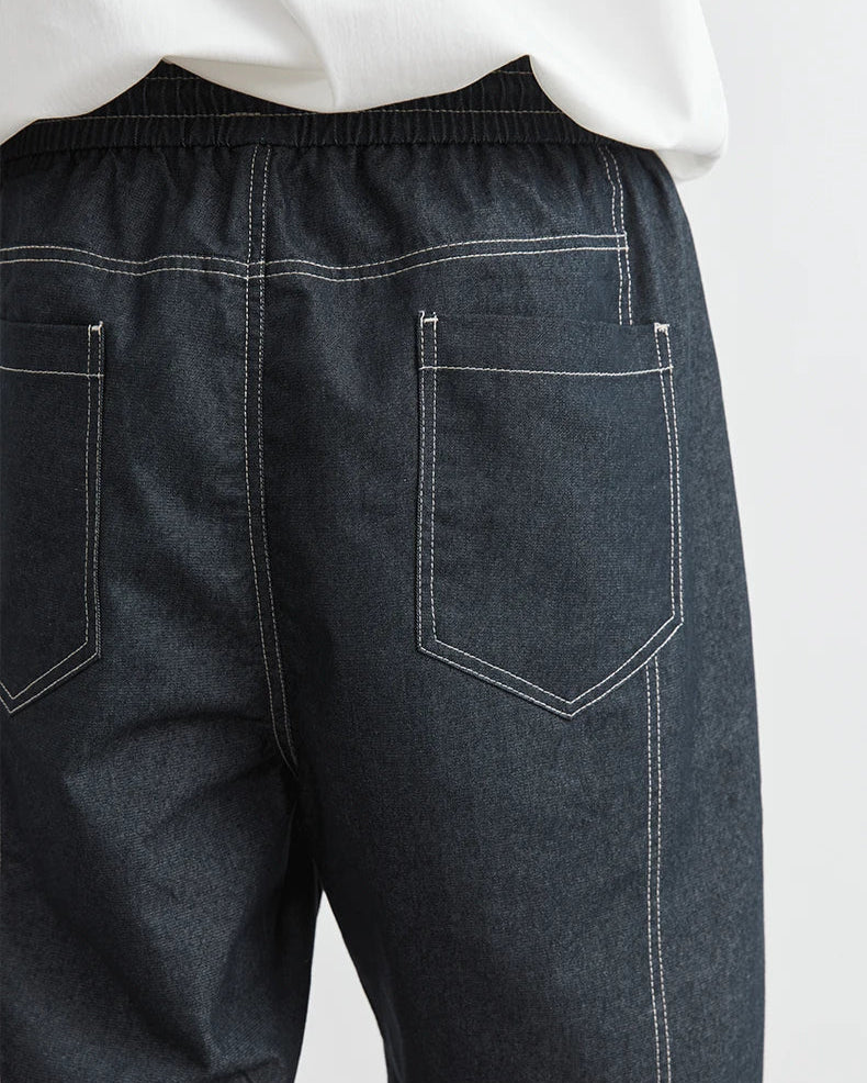 Dark gray pants with white stitching on a white background