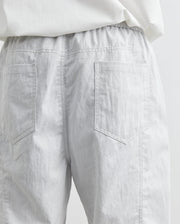 Light gray pants with a white shirt on a light gray background