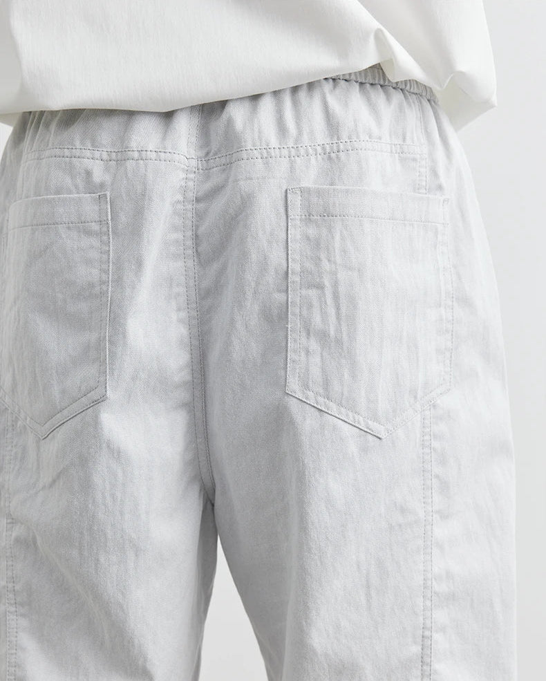 Light gray pants with a white shirt on a light gray background