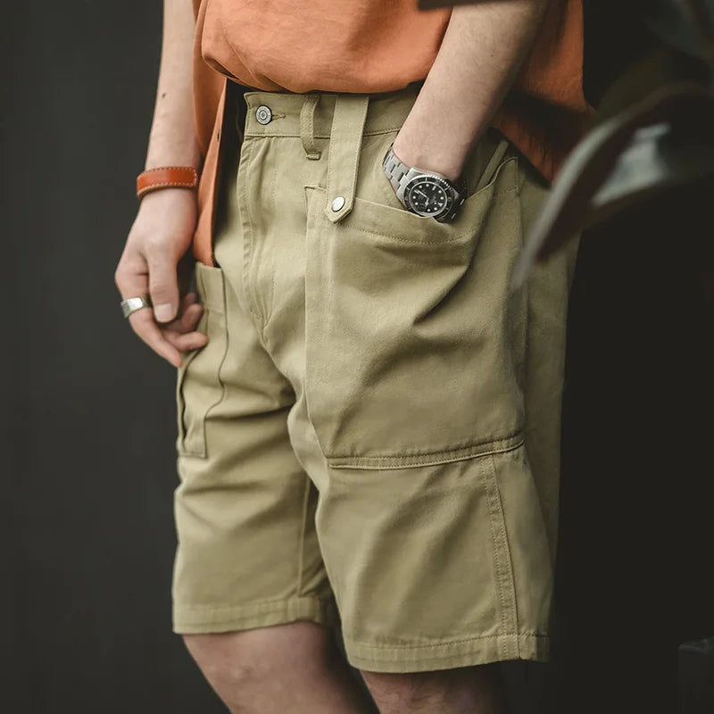 Person wearing beige shorts with a dark background