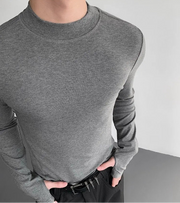 Gray long-sleeve shirt worn by a person on a plain background