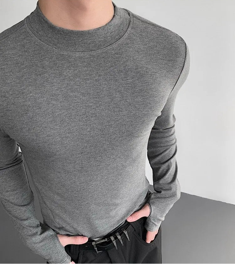 Gray long-sleeve shirt worn by a person on a plain background