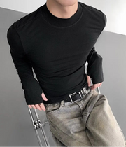 Person wearing a black long-sleeve shirt and light gray pants on a gray background