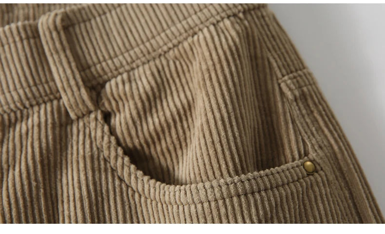 Close-up of a brown corduroy fabric with a button, on a white background.