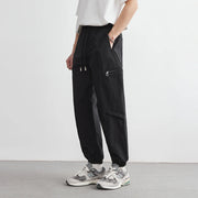 Person wearing black cargo pants with a white background