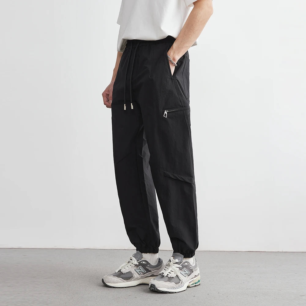 Person wearing black cargo pants with a white background