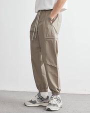 Person wearing beige cargo pants and sneakers on a white background