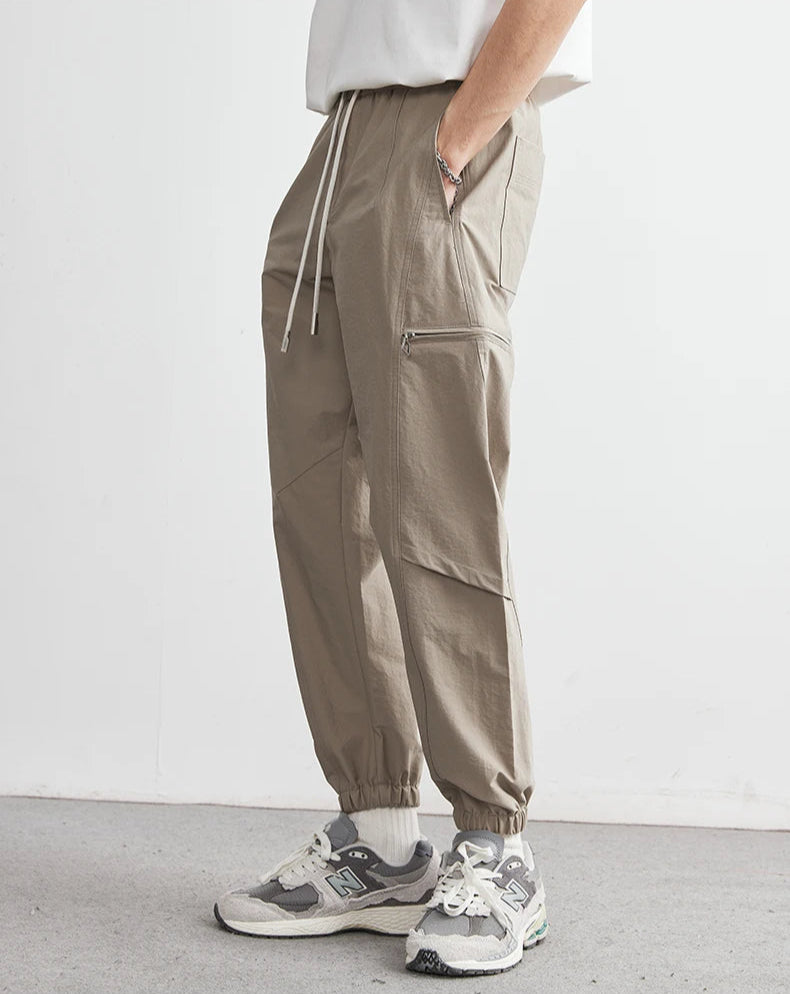 Person wearing beige cargo pants and sneakers on a white background