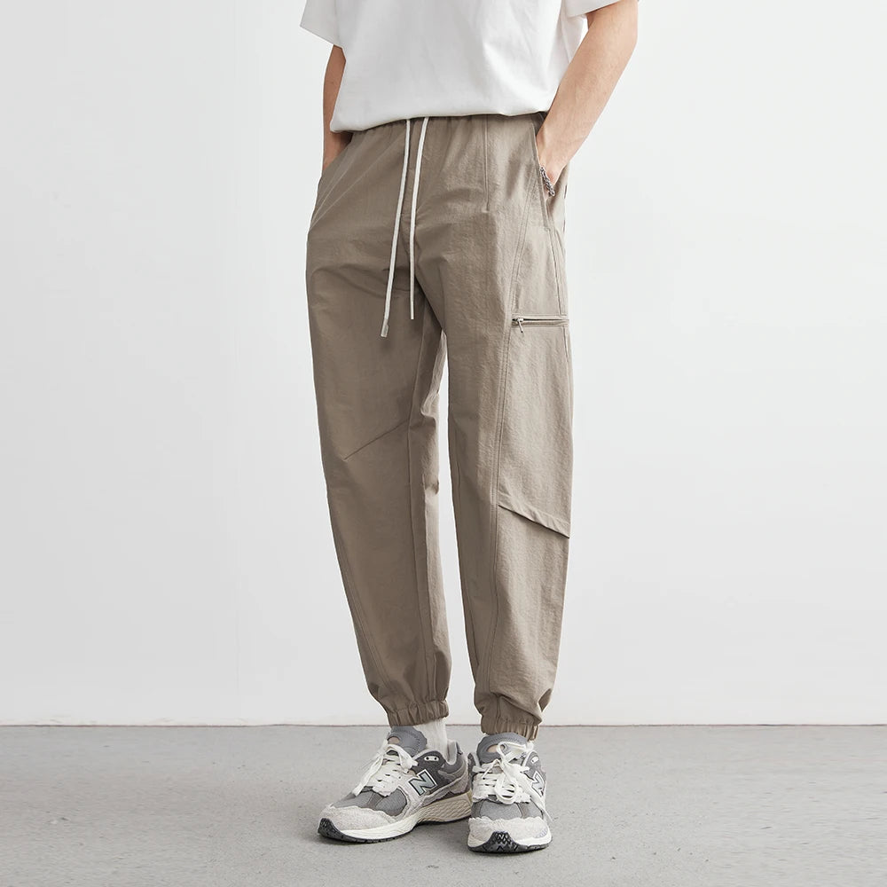 Person wearing brown cargo pants and white sneakers on a plain background